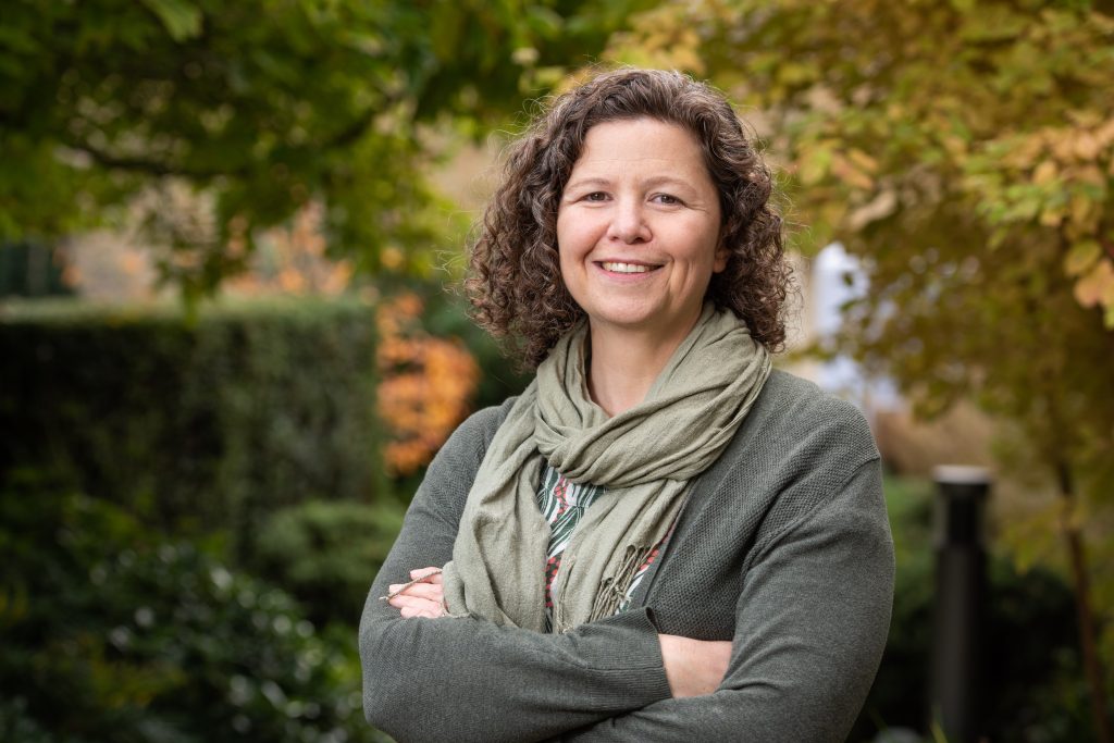 Charlotte Ryland's profile photo. She is standing in the College gardens