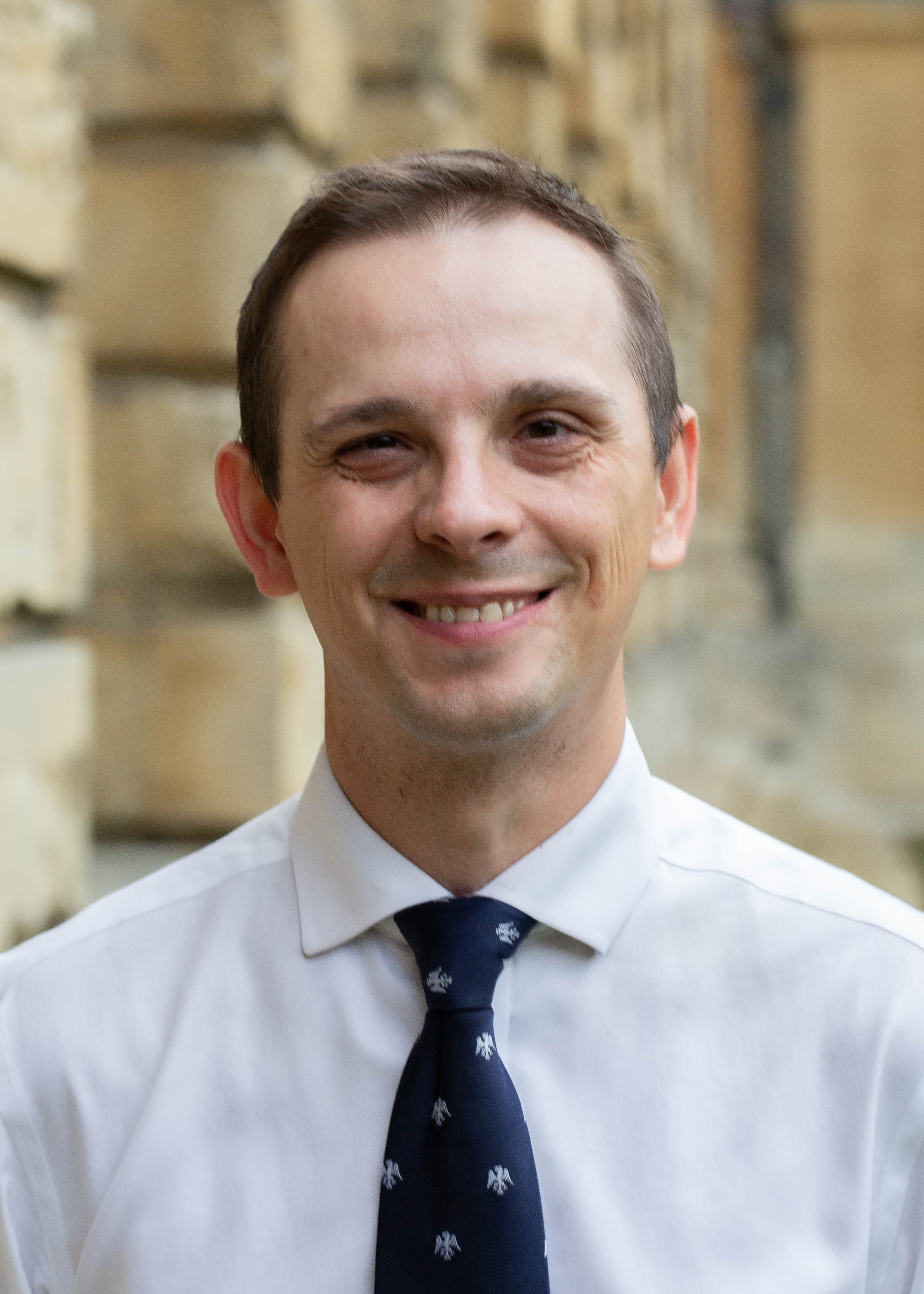 Rasti wearing a white shirt and blue tie with silver eagles