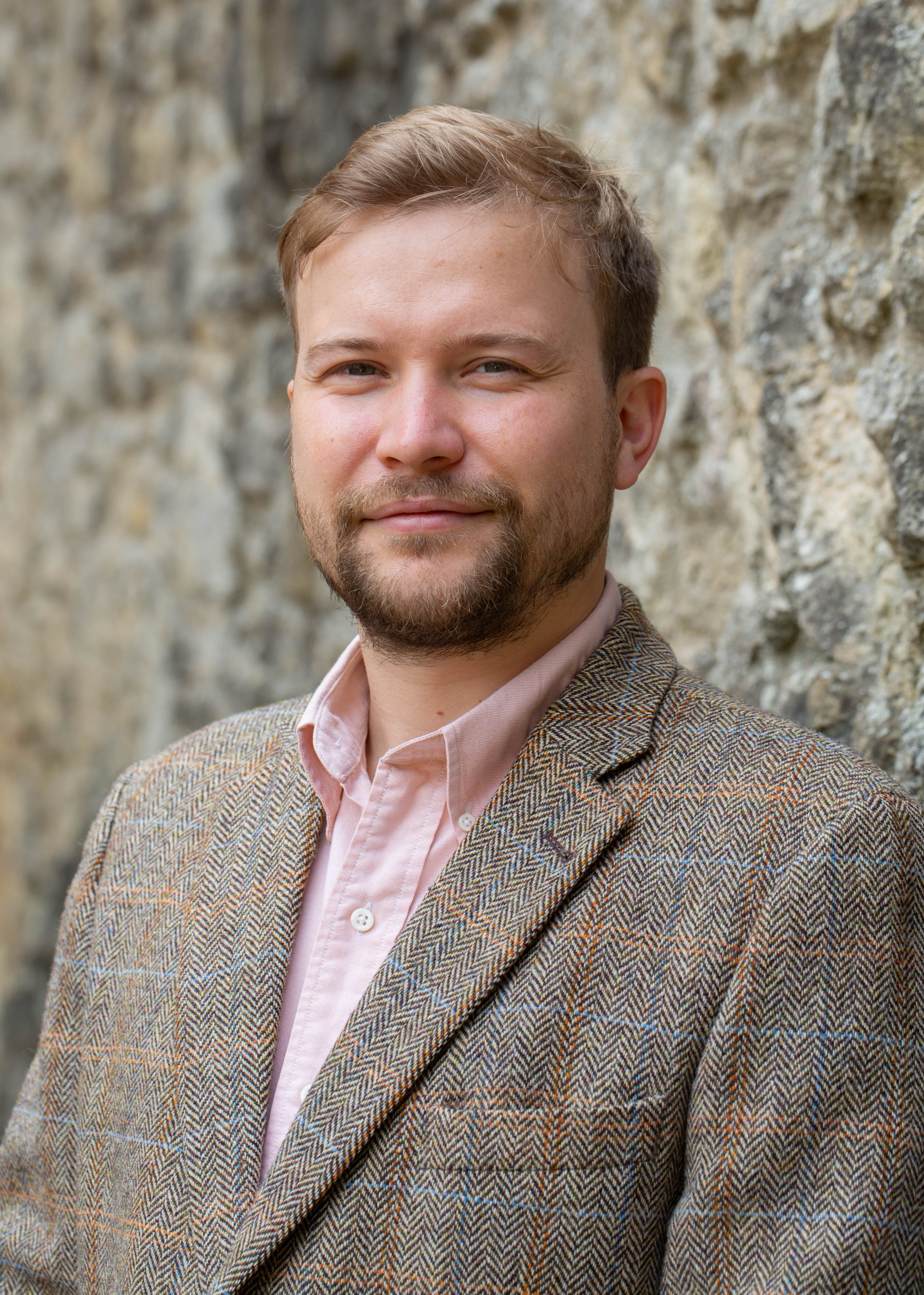 Daniel Kupiec-Ashton profile photo with stone wall background