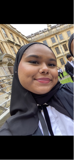 Profile photo of Alina smiling and wearing Sub Fusc (white shirt and black ribbon) for Matriculation Day