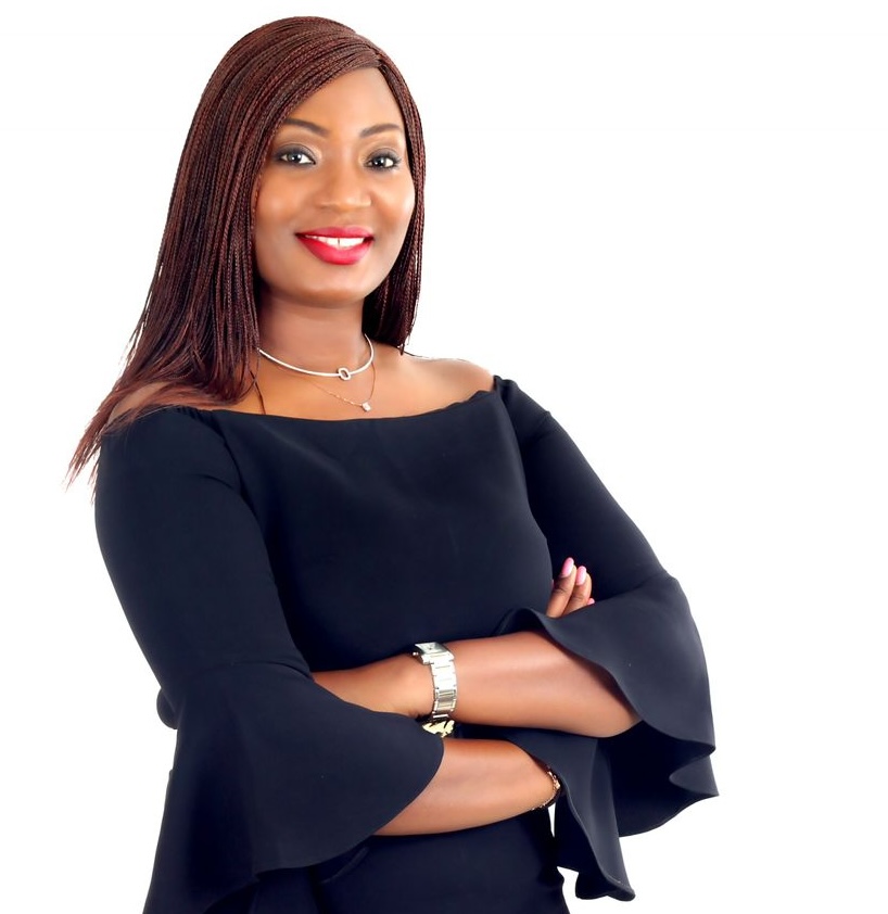 Dr Hassanatu Mansaray wearing a black dress and bright red lipstick photographed against a blank white background.