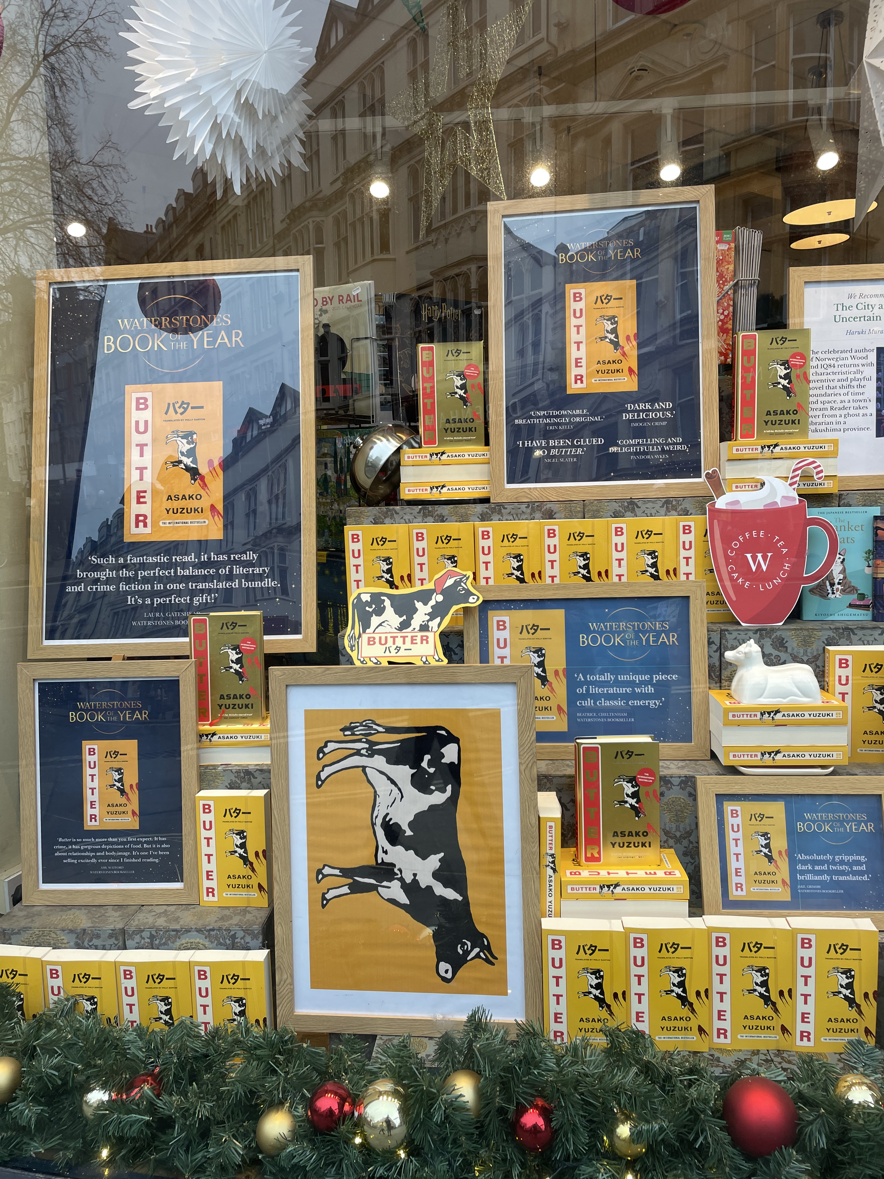 the window display for Butter at Waterstones, Oxford. There are multiple copies of the book itself along with frames images of parts of the cover, including a cow on a yellow background which is rotated vertically