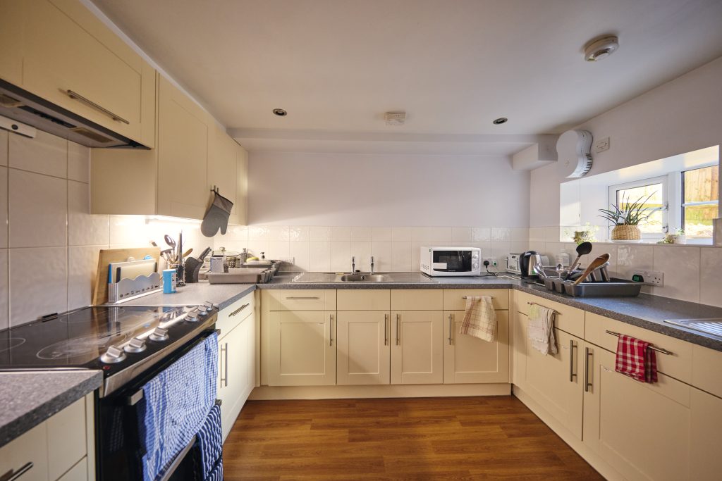 James Street kitchen with cream doors, hob, microwave, sink and natural light